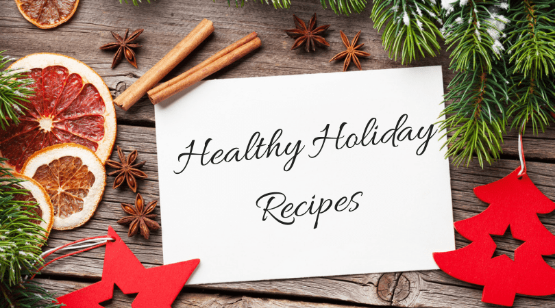 A wooden table adorned with dried citrus slices, cinnamon sticks, star anise, pine branches, and red star and tree ornaments evokes a festive spirit. At the center, a card reads "Healthy Holiday Recipes," reflecting tips recommended by your local medical center for holiday wellness.